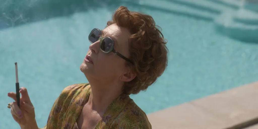 donna in piscina con occhiali da sole